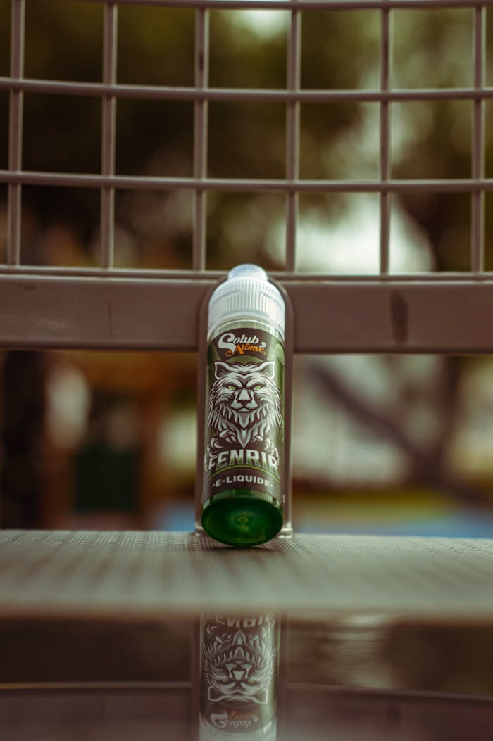 A green e-liquid bottle on a bench outdoors in Casablanca, showcasing its design and packaging.